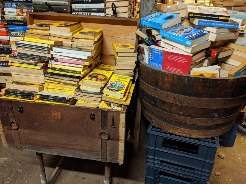 Des livres rangés dans un vieux coffre et une bassine en bois dans la librairie Acqua Alta de Venise en Italie